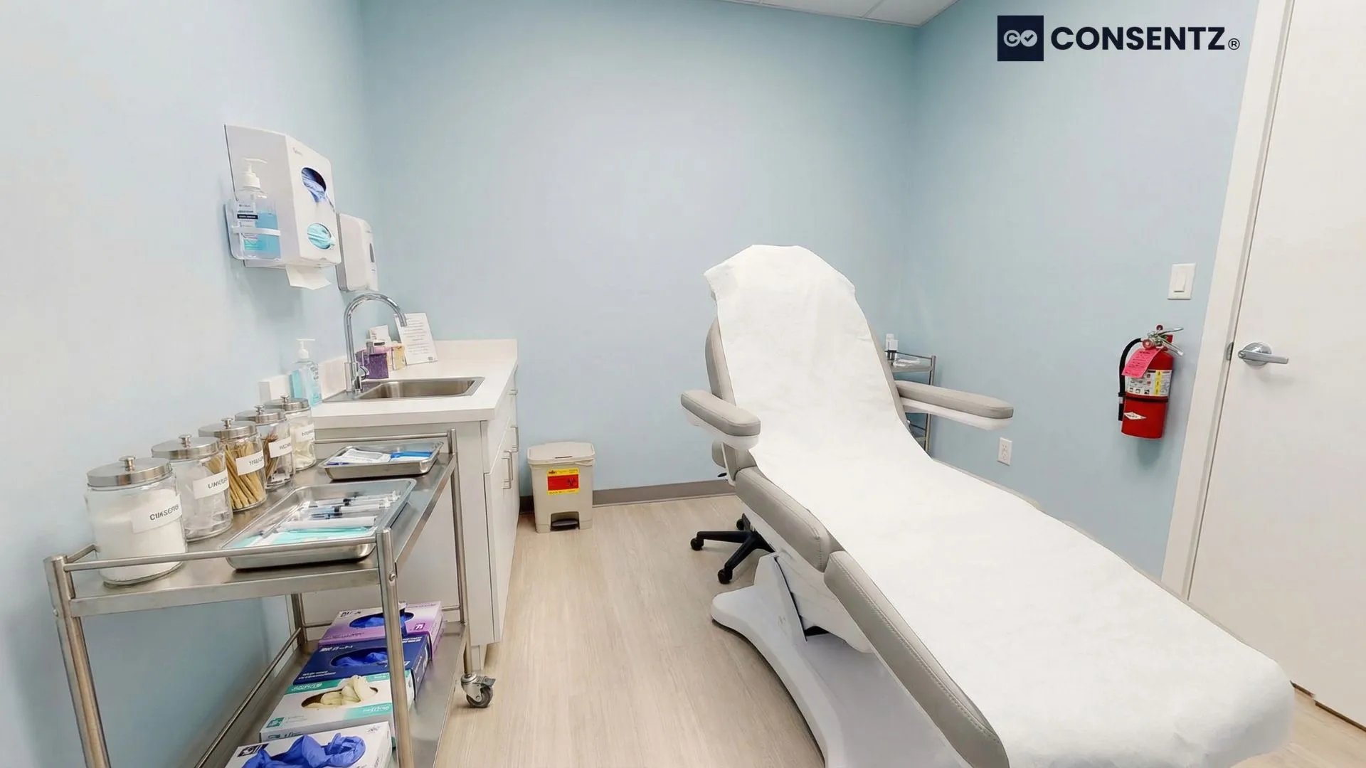 Well-organized aesthetic clinic treatment room showing proper safety equipment and organization