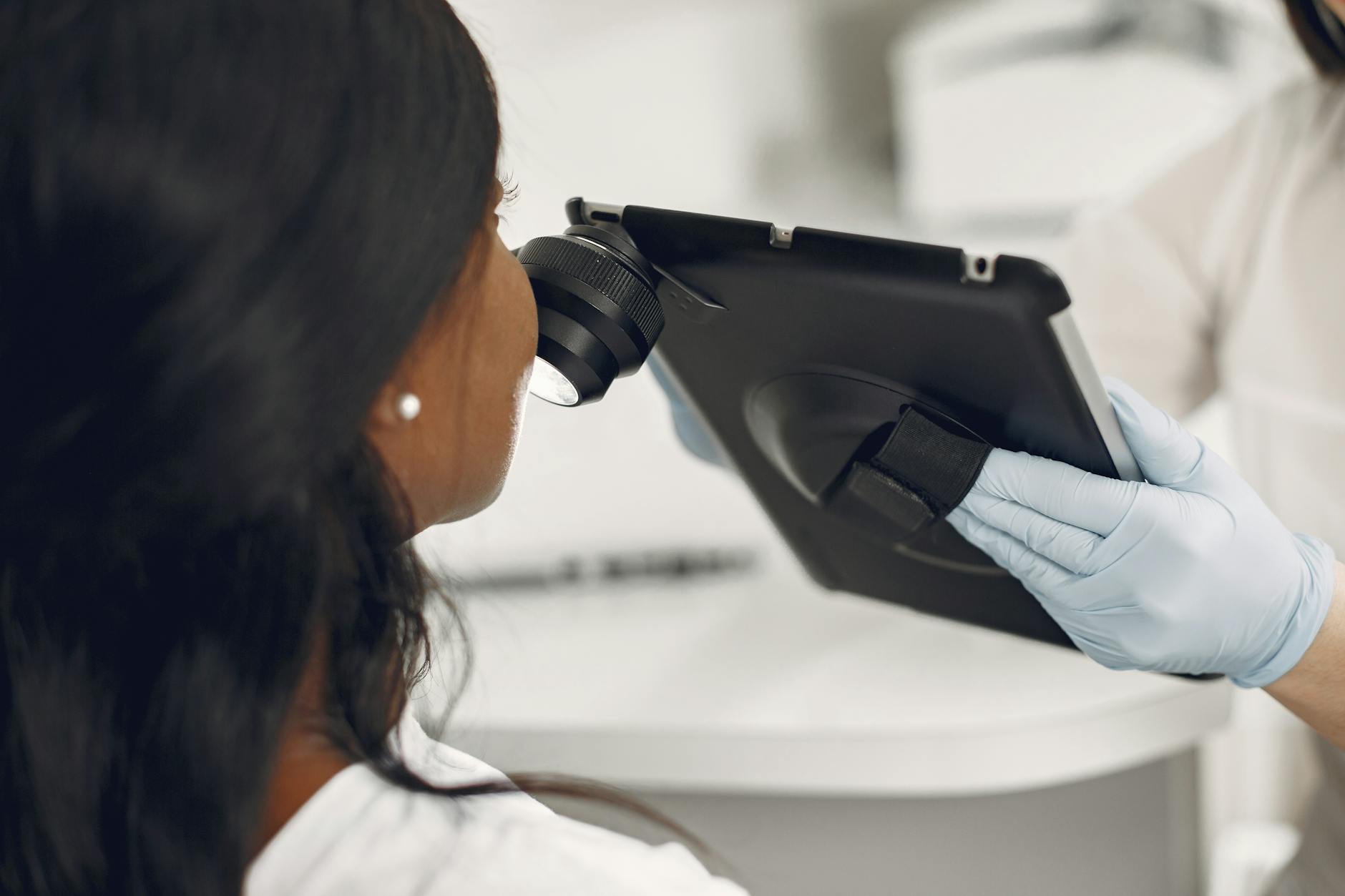 A dermatologist examining a patient's skin with a dermatoscope