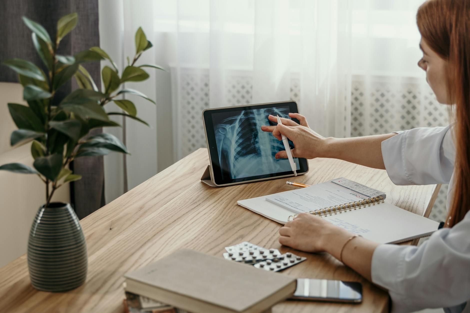A doctor and patient looking at a tablet displaying clinic ehr software.